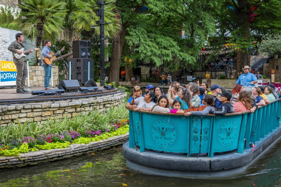 River barge floating by with people and man singing at Arneson River Theatre