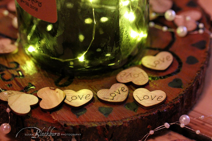 Bottom of wine bottle with lights and wooden hearts
