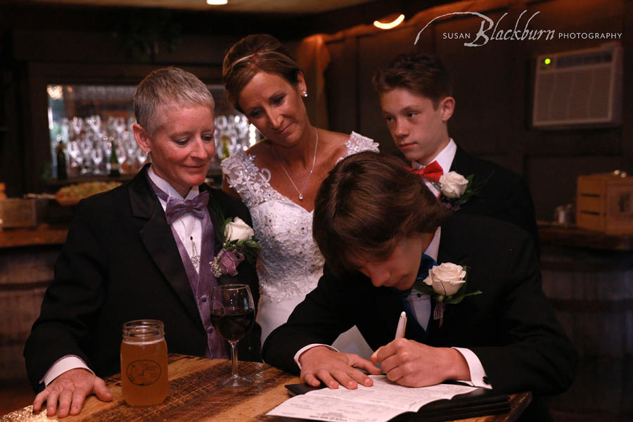 Couple during wedding with sons signing paper