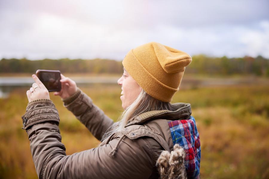 girl with yellow hat recording landscape