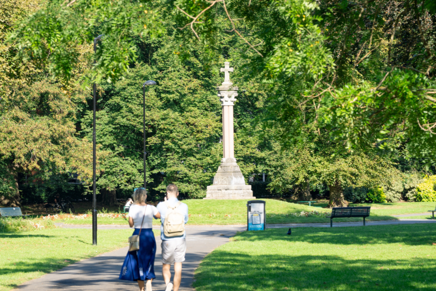 Two people in the distance walking in Queens Park