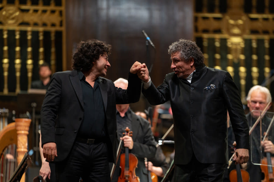 A male musician and conductor congratulating each other.