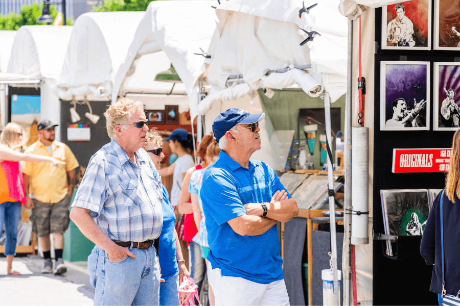 Visitors looking at an art vendor at Mayfest