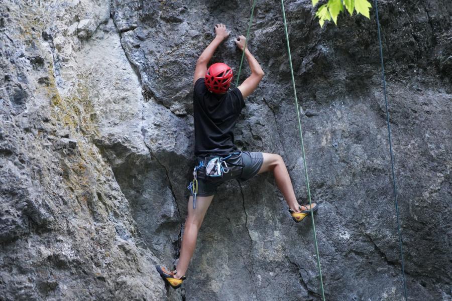 young man rock climbing outdoors