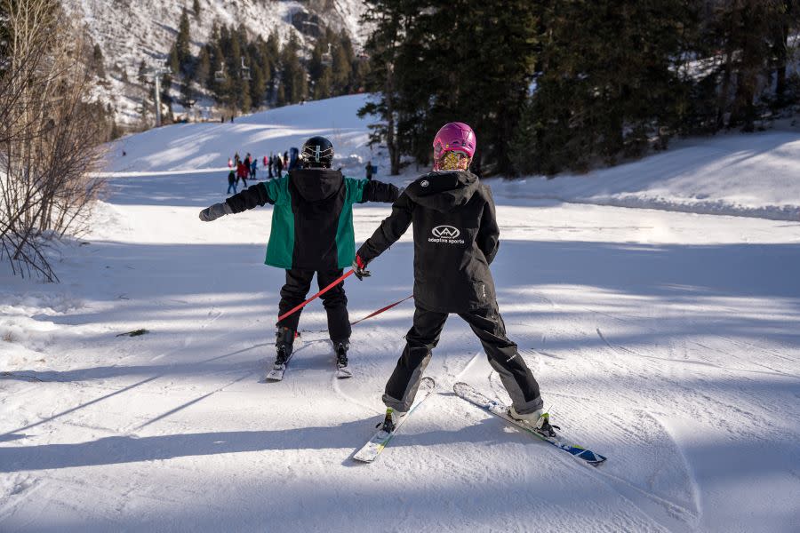 Jodi assists Chase down the mountain with adaptive equipment