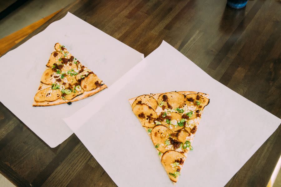 two pizza slices on table at Slab Pizza