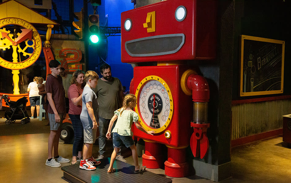 Family playing with huge robot in the CurioCity exhibit at Science Museum Oklahoma