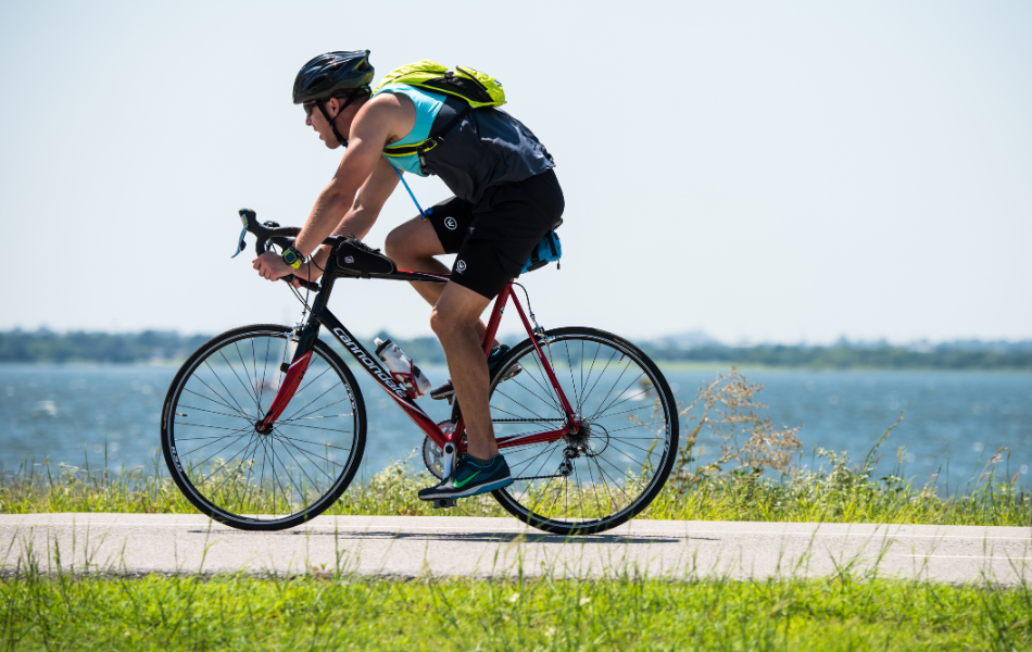 Man riding bicycle with Lake Hefner in the background
