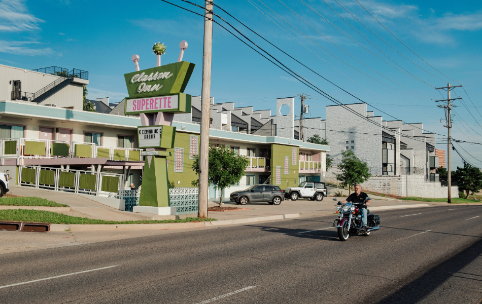 Man driving a motorcycle in front of Classen Inn