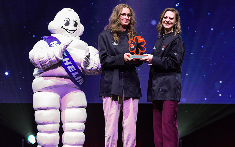 Two women holding award next to MICHELIN Man