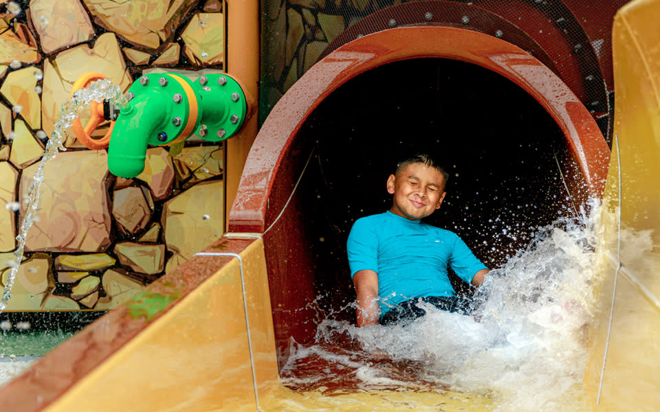 Kid splashing at end of water slide at Schlitterbahn.