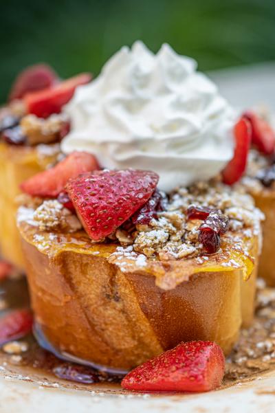 Thick slices of french toast topped with whipped cream, strawberries, syrup and powdered sugar from Billy's