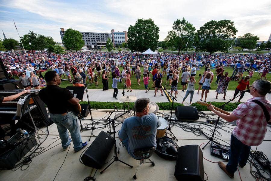 Picture of a crowd at Big Spring Park gathered to watch a band play. Perspective is from the band's POV
