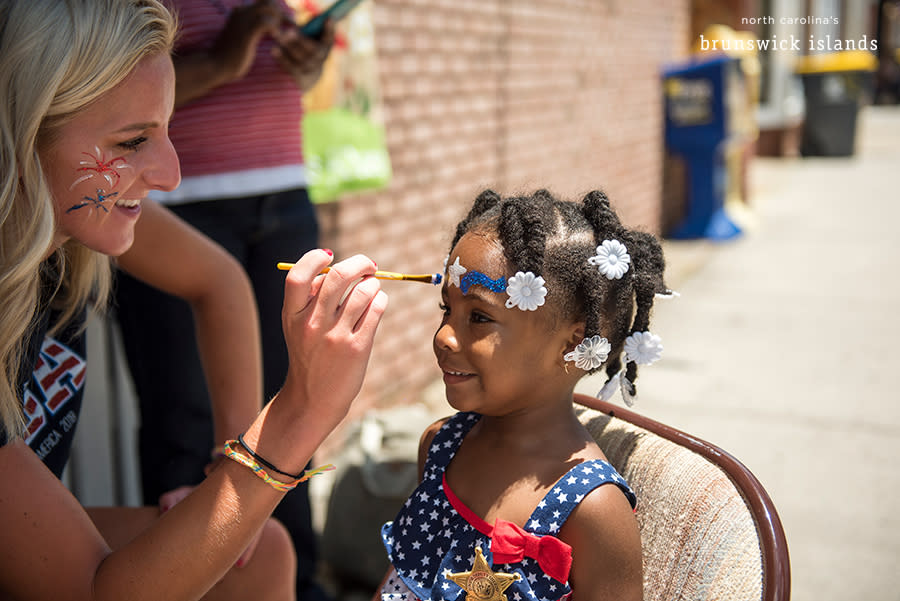 a little girl getting her face painted at the NC 4th of July Festival in Southport