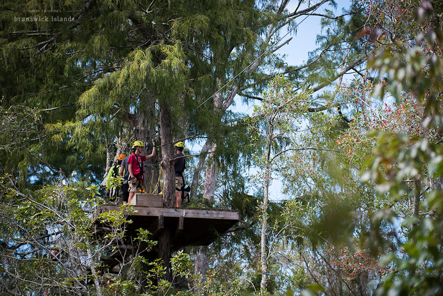 people standing on a zipline platform