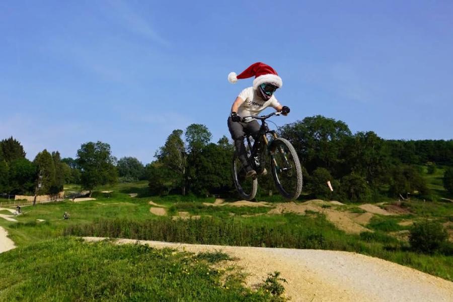 Flyup 417 child wearing santa hat on mountain bike mid air over jump