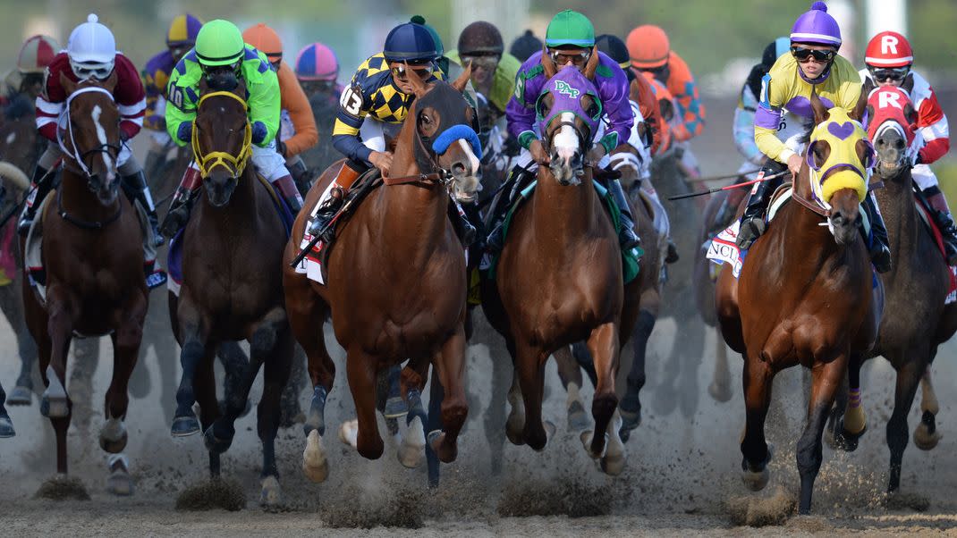 Horses and jockeys racing toward the camera at the Kentucky Derby