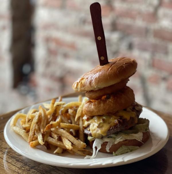 BBQ Bacon Burger -Smothered in BBQ sauce and topped with bacon and cheddar cheese. Served with lettuce, mayo, pickles and topped with beer battered onion rings