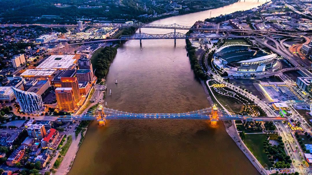 The Ohio River runs vertical up the photo and bends to the right at the top. Covington is on the left and Cincinnati is on the right. Three bridges are seen spanning the river.