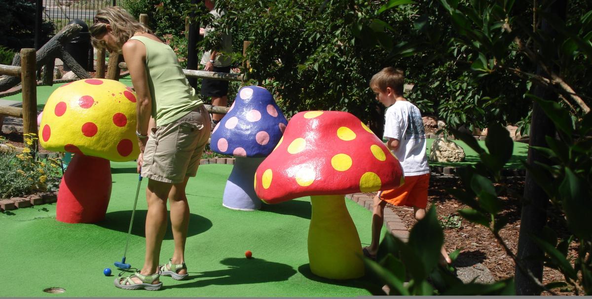 A woman and child playing putt putt golf