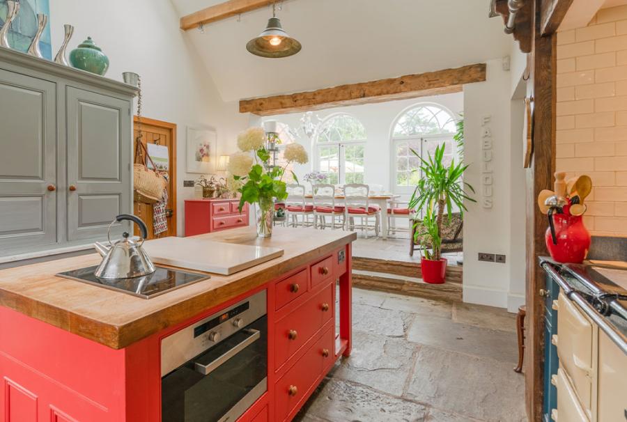 country style Kitchen in a Bolthole Retreats cottage. Flagstone floors red and sage kitchen cabinets