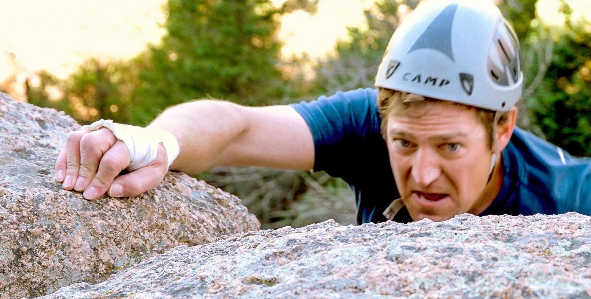 Climber gripping a rock edge during a technical climb at Vedauwoo, a premier destination for challenging rock climbing in Wyoming.