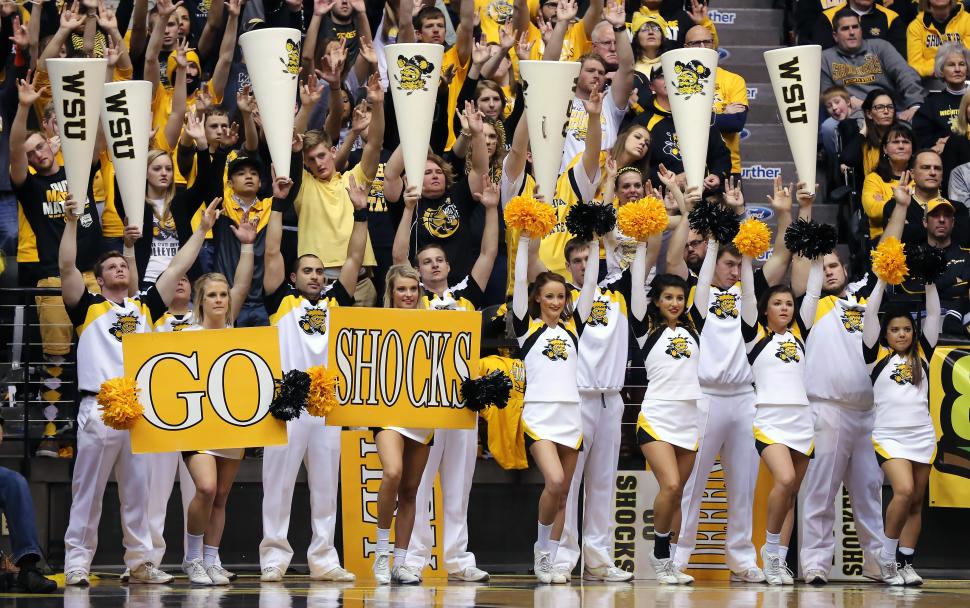 The cheer team cheers on the Wichita State University basketball team from the sidelines.