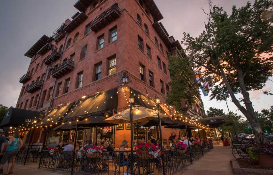 Exterior view of Hotel Boulderado in Boulder, Colorado, where people are dining on the patio.