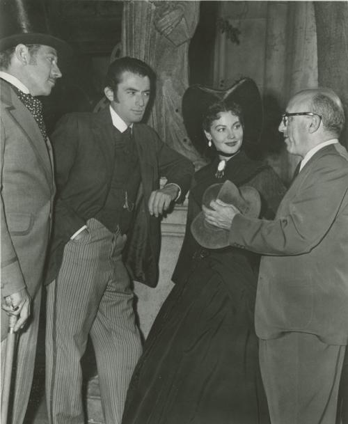 Melvyn Douglas, Gregory Peck, and Ava Gardner speaking with director Robert Siodmak on the set of The Great Sinner.