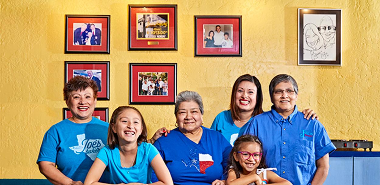 Regina Estrada and female family members smile for a portrait inside Joes Bakery and Coffee Shop