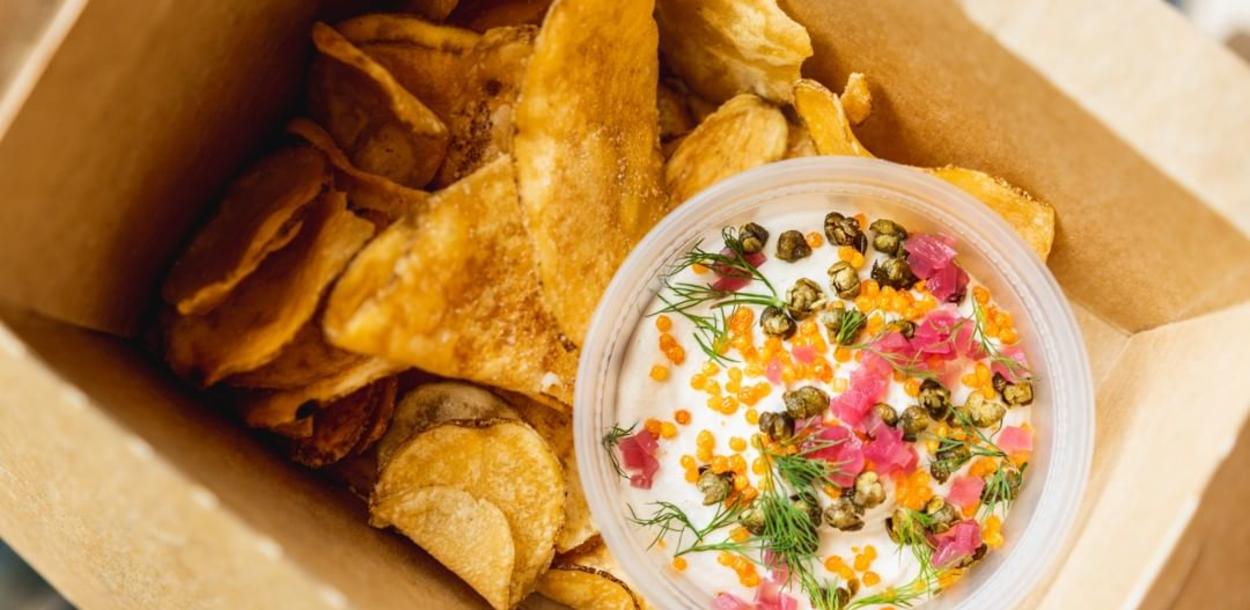 Smoked Salmon Sour Cream Dip and chips in takeout container from Drop Kick in Austin TExas