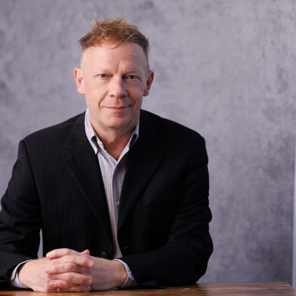 Photo of Robert Versluis seated with his hands clasped