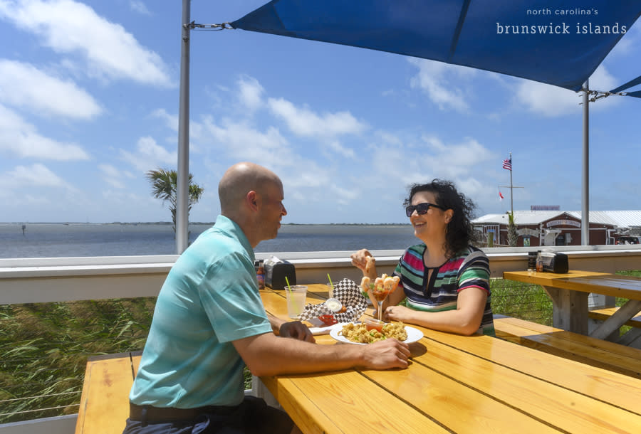 Two people waterfront dining at the Frying Pan in Southport, NC.
