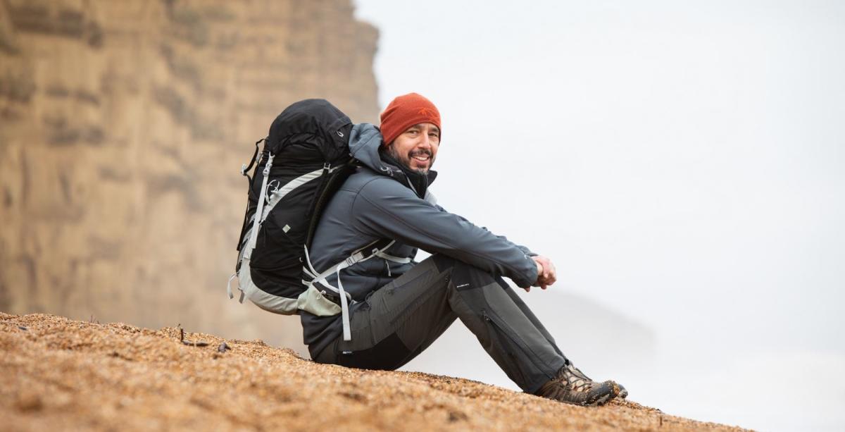 Fossil tour guide Martin Curtis sitting on a beach on the Jurassic Coast in Dorset