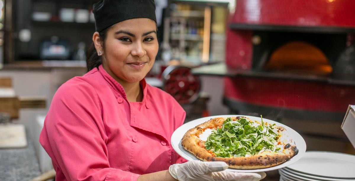 Lady holding fresh pizza