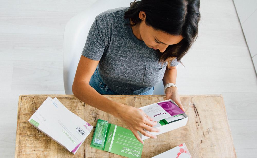Woman opening an at-home testing kit from Everlywell based in Austin Texas