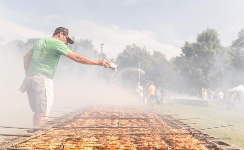 man salting cooked chicken at manchester chicken broil