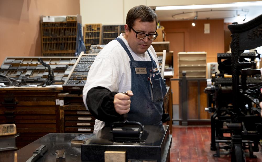 Sacramento History Museum's Jared using the Printing Press