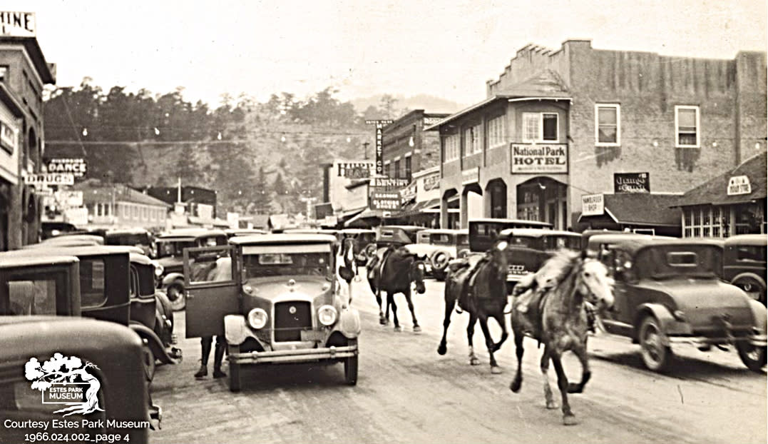 A photograph from the 1920s showing horses on a street running between cars