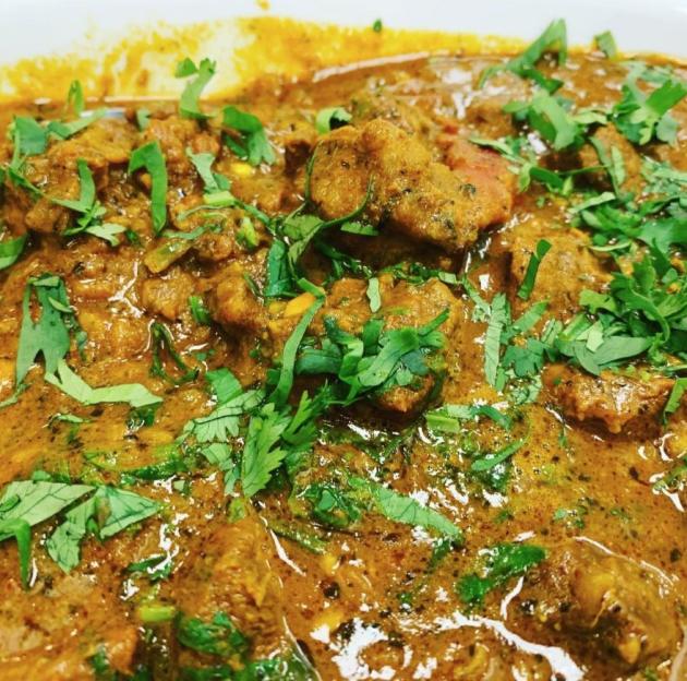 Plate of chicken covered in curry sauce