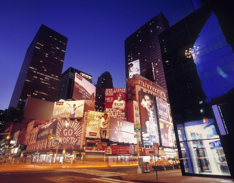 nighttime view of times square with the skyline
