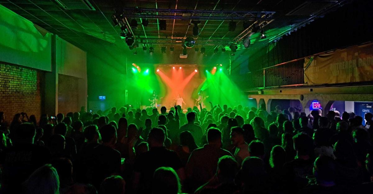 Large crowd watching band play on stage at The 1865