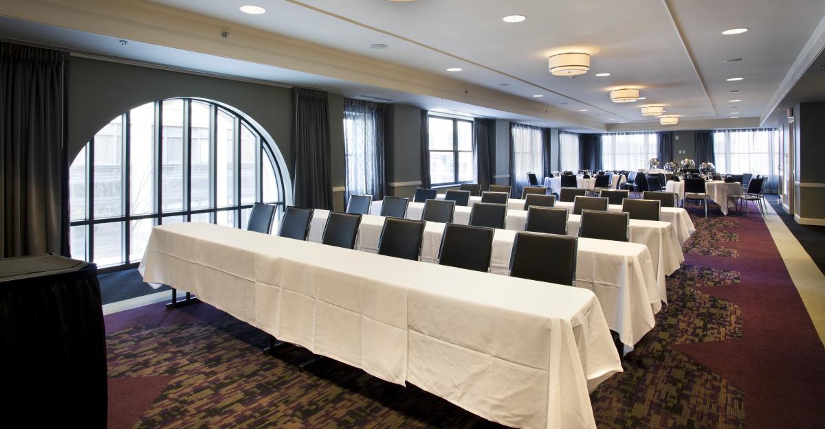 Chairs and tables are set up for a meeting at a boardroom inside the Ambassador hotel