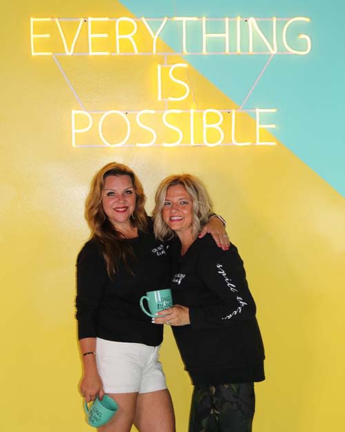 Kristen Reynolds and Sharon Wyman from Discover Long Island in front of a neon sign that reads Everything is Possible