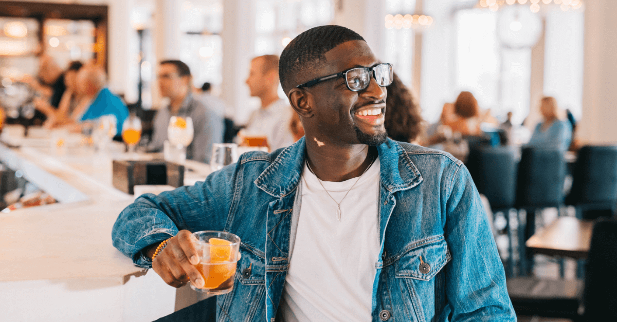 man drinking cocktail at a bar