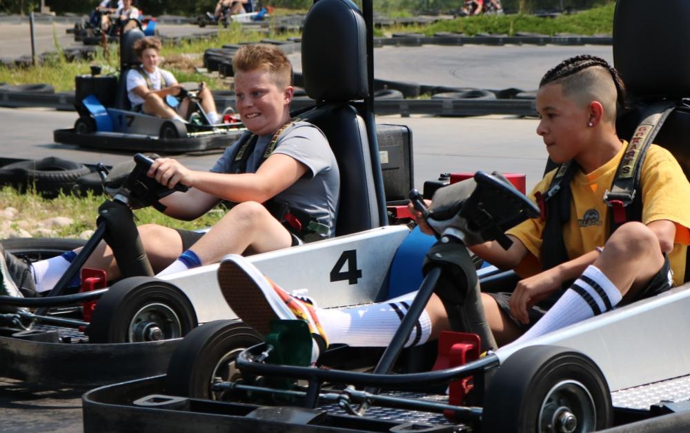 Two kids ride go karts at Fort Fun