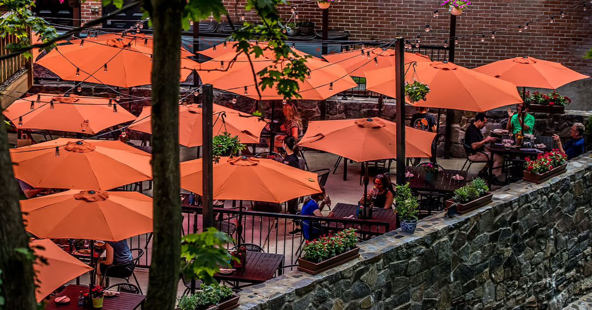 People Sitting Under Red Umbrellas On The Patio Of Umi Sushi In Ellicott City