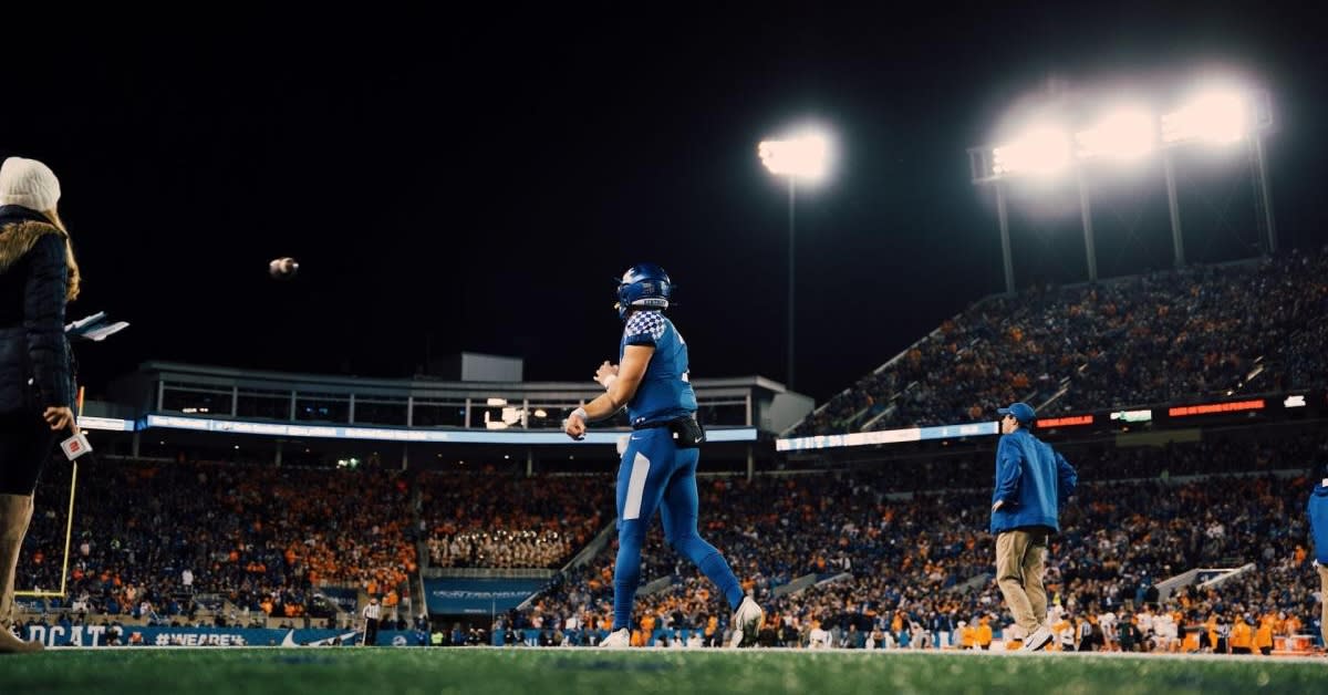 A Kentucky quaterback throwing a football at kroger field stadium.