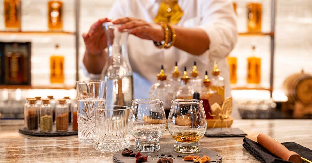 Person pouring drink in at a bar.