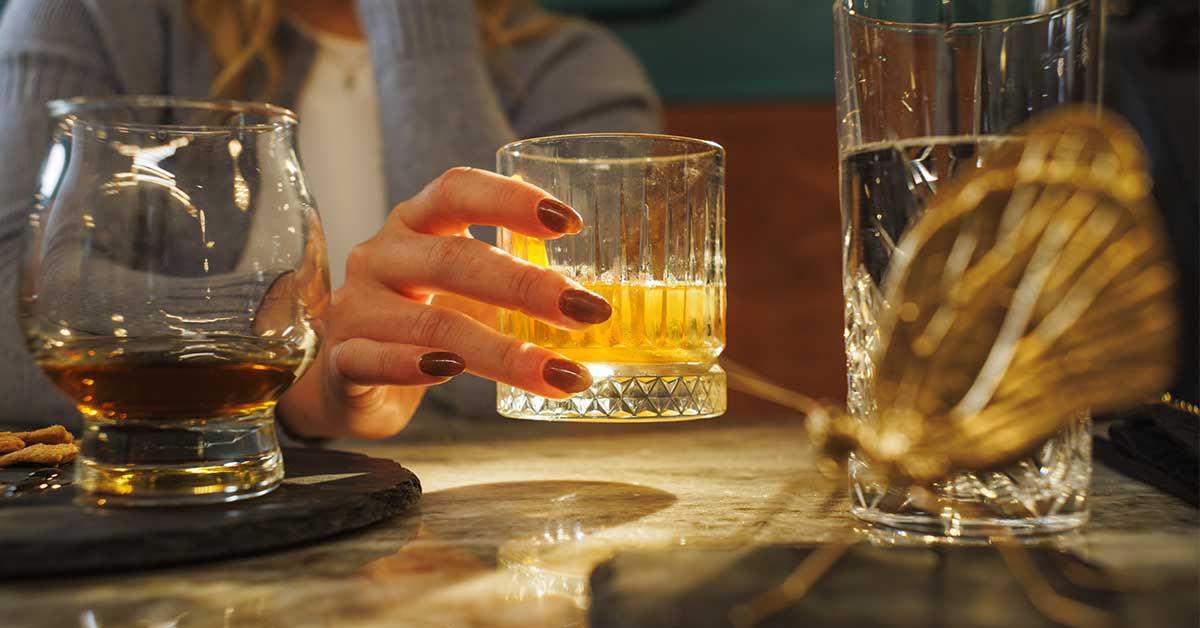 Woman holding a glass of bourbon in lexington, Kentucky.